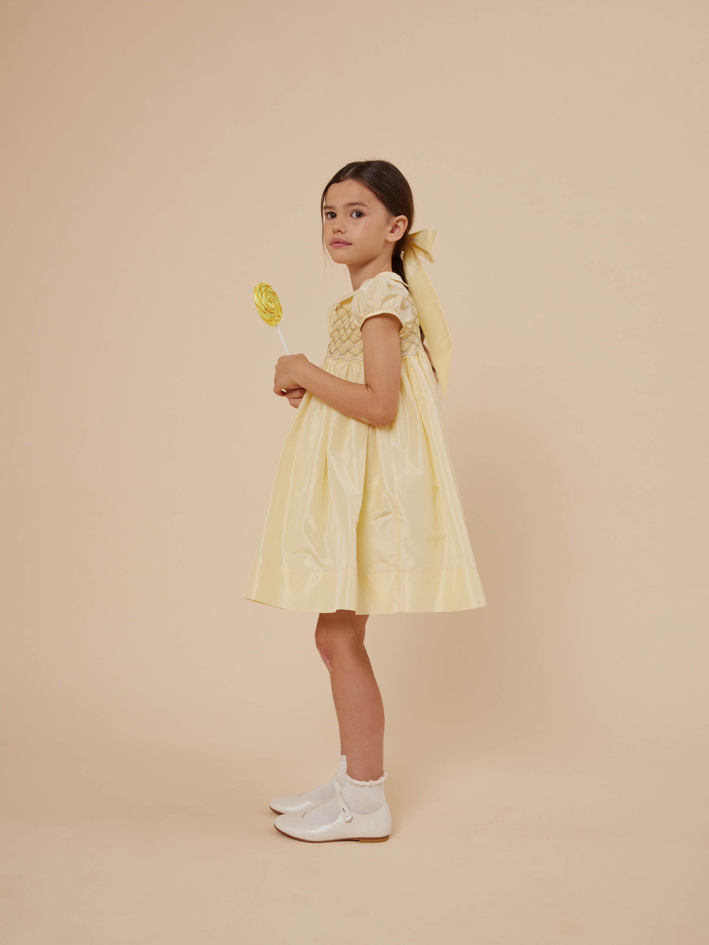 Verano 2024 look con vestido de tafetán de seda amarillo de niña