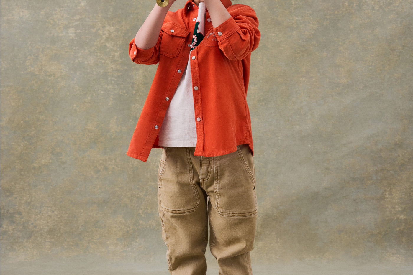Invierno 2024 look con camisa abotonada naranja de niño