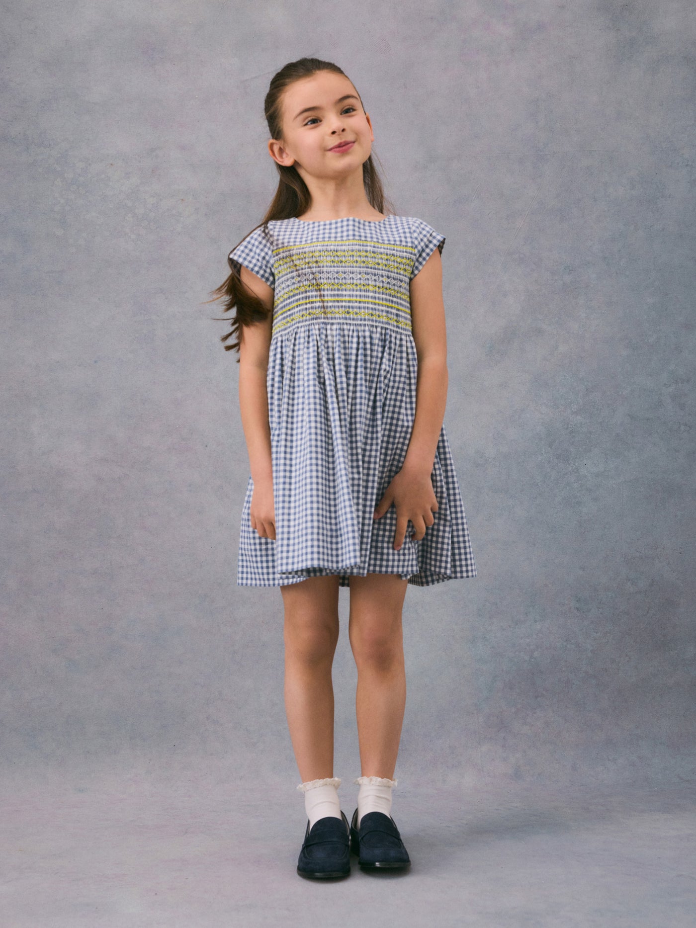 Invierno 2024 look con vestido con punto smock de niña