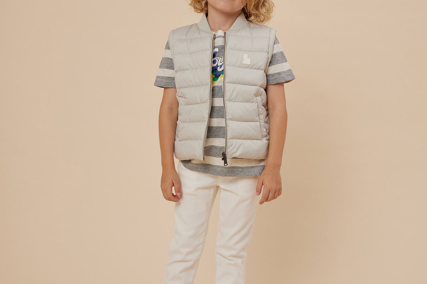 Verano 2024 look con chaqueta puffer sin mangas de niño