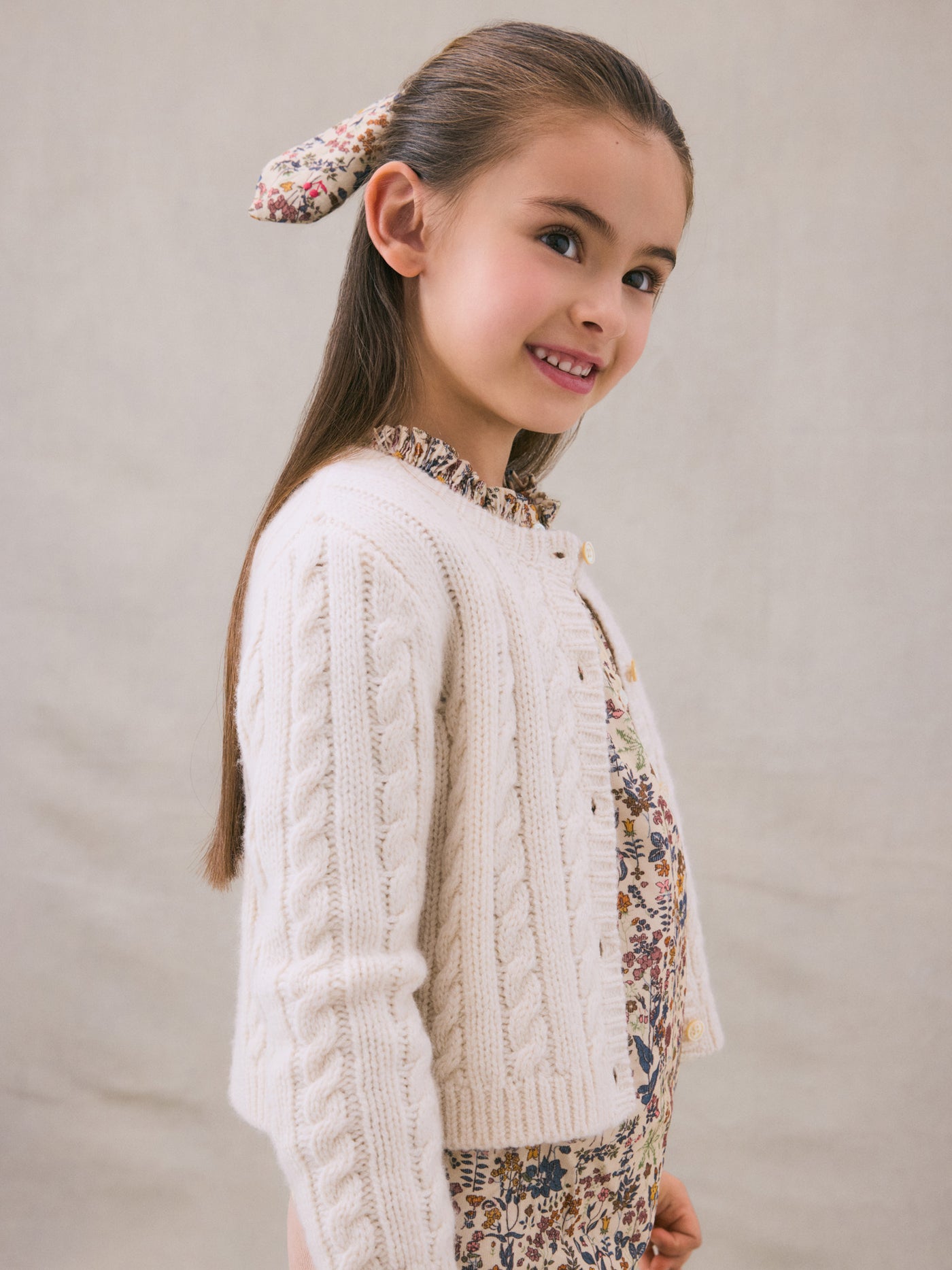 Invierno 2024 look con cárdigan de punto trenzado blanco de niña