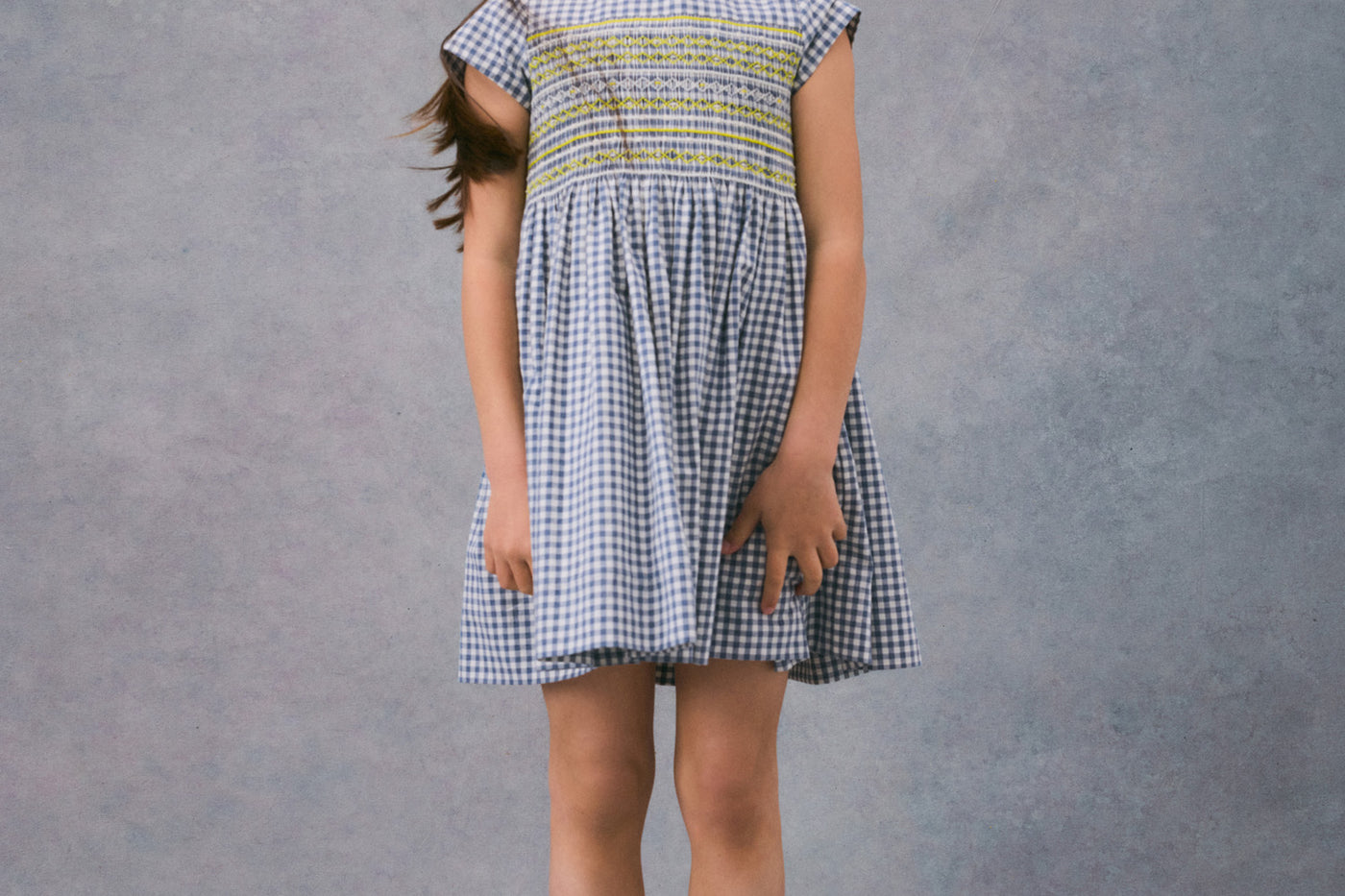 Invierno 2024 look con vestido con punto smock de niña