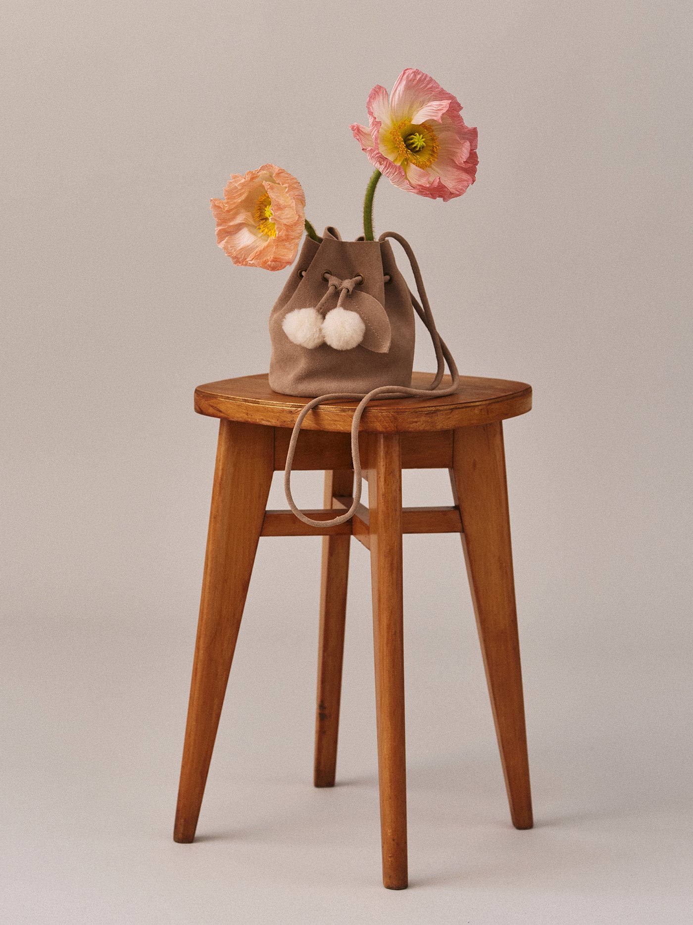 Borsa Jessika in pelle scamosciata e pompon in pelliccia sintetica